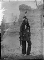 Sioux brave in costume, rock background