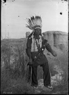 Sioux brave in feather headdress, butte background