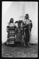 Man, woman and girl outside tipi