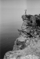 Fran Hall standing on a cliff overlooking water.