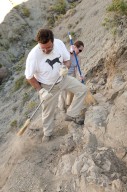 L-R: Dr. Kirk Johnson and a DMNS Volunteer sweep dirt away from an excavation site.
