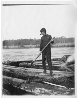 Man aboard a log raft