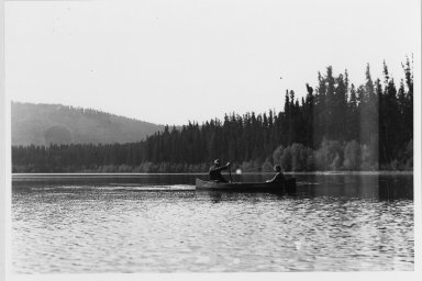 Unidentified man and woman in canoe