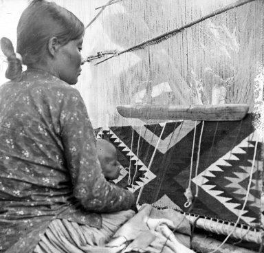 Apache woman and child at loom.