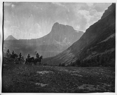 Five riders crossing mountain meadow