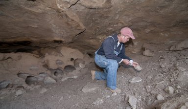Dr. Steve Nash examines a piece of debris at the Hinkle Park Cliff Dwelling.