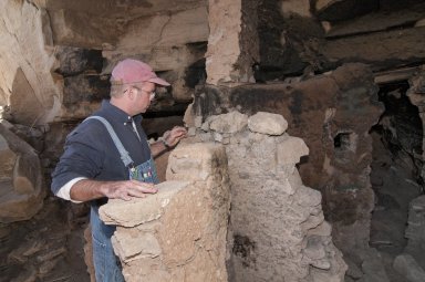 Dr.Steve Nash looks at the top of a wall at the Hinkle Park Cliff Dwelling.