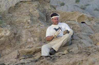 Dr. Kirk Johnson, DMNS Vice President of Research and Collections and Chief Curator, uses a rock hammer to reveal a leaf specimen on the Kaiparowits Plateau.