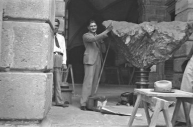 Museum workers posing with Meteorite on pedestal