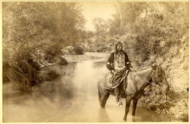 Indian male on horse in stream