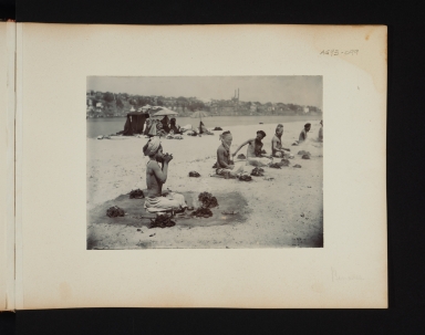 Five seated Fakirs surrounded by small fires in Benares, India.
