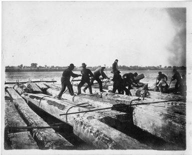 Men aboard a log raft